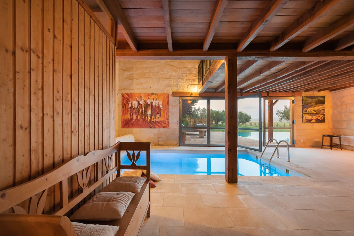 La piscine intérieure chauffée, sous charpente en bois, ouverte toute l'année.